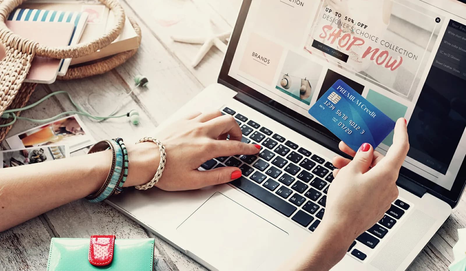 Woman holding a credit card while online shopping for fashion products.