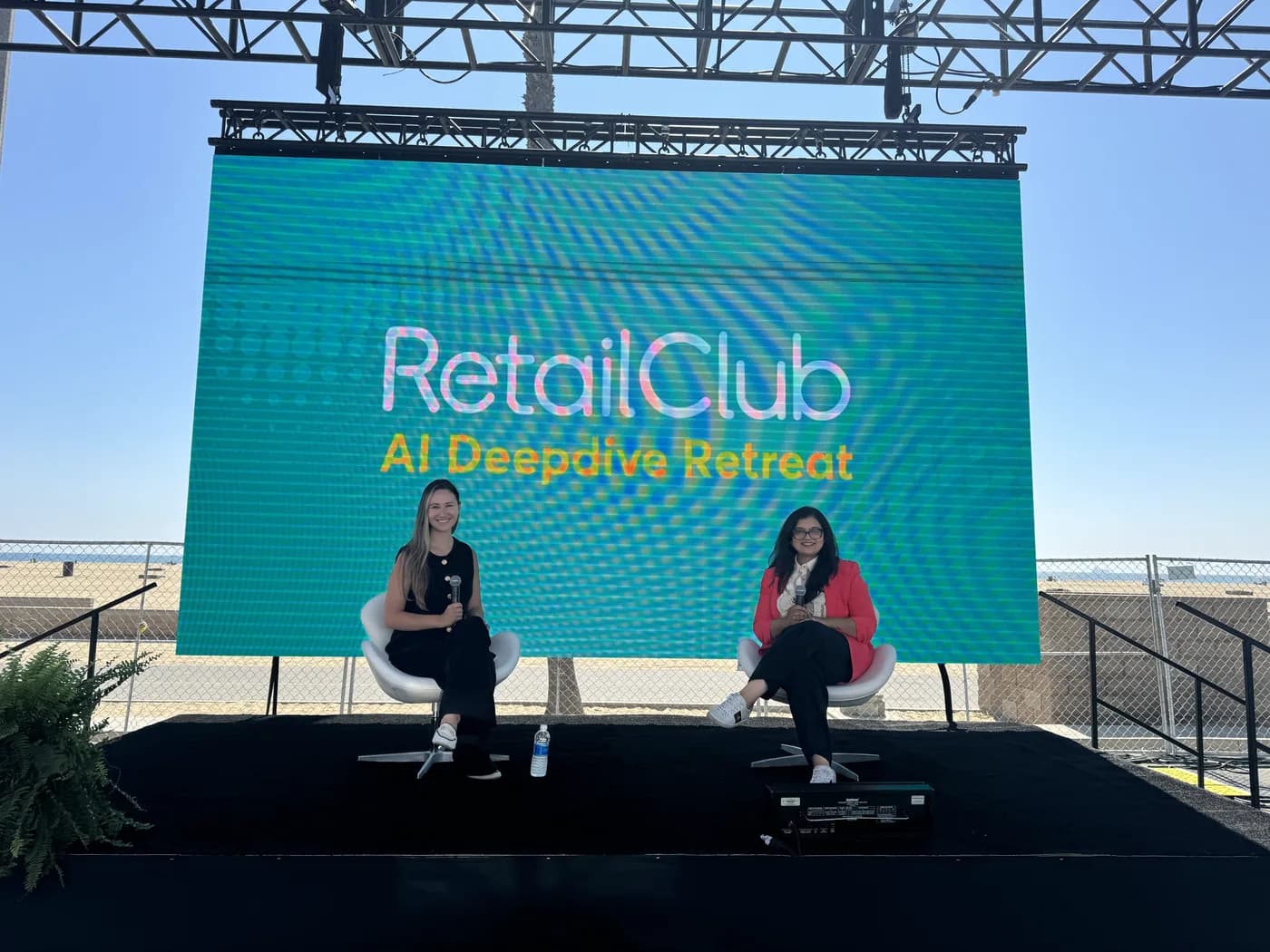 Lily AI and Fabletics on stage in front of the RetailClub AI Deepdive Retreat screen at Retail Club 2025.