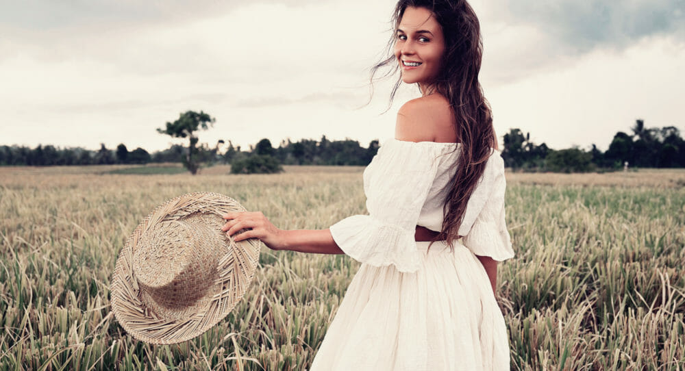 A woman in a white dress in an open field