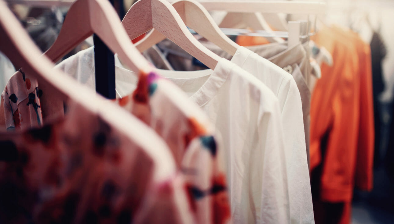 A variety of clothing and fashion items hanging on a rack.