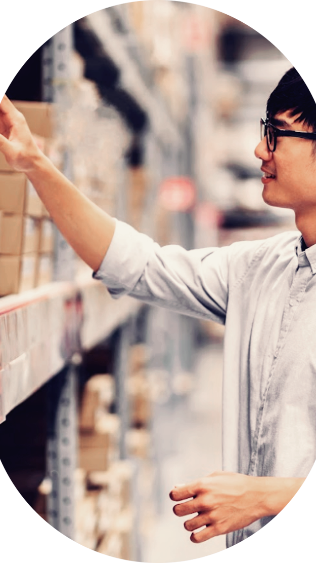 Man looking at retail stock in warehouse trying to predict demand forecasting.