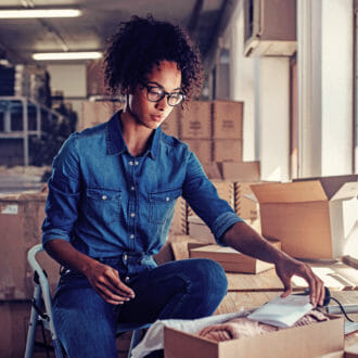 Female merchandiser with glasses at work with the help of AI science for product attribution.