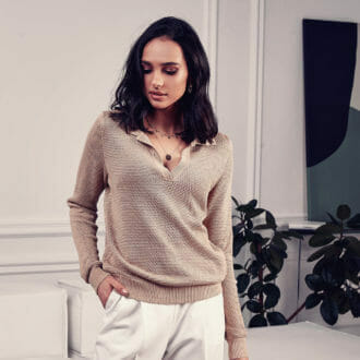 Fashion model posing in a soft touch tan sweater.