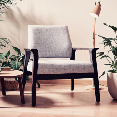 Mid-century modern attributed accent chair in a clean home surrounded by potted plants. Home Product Attribution.