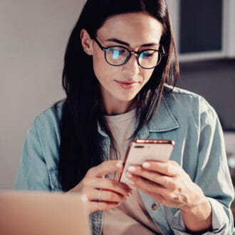 Woman with glasses online shopping on her phone.